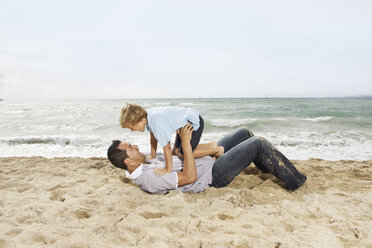 Spanien, Vater und Sohn haben Spaß am Strand von Palma de Mallorca, lächelnd - SKF001202