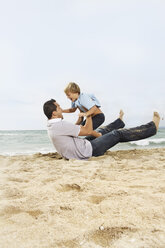 Spanien, Vater und Sohn haben Spaß am Strand von Palma de Mallorca, lächelnd - SKF001203