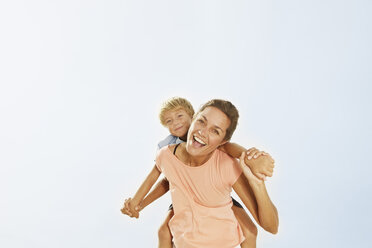 Spain, Mother giving piggy back ride to son, smiling - SKF001204