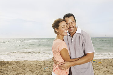 Spain, Mid adult couple on beach at Palma de Mallorca, smiling - SKF001220