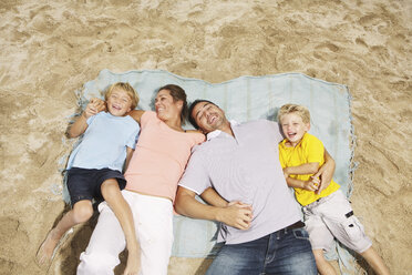 Spanien, Familie liegt am Strand von Palma de Mallorca, lächelnd - SKF001223