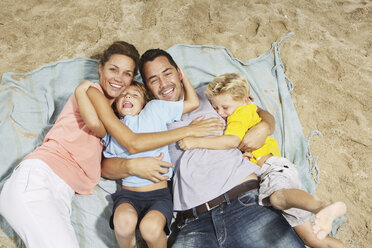 Spanien, Familie liegt am Strand von Palma de Mallorca, lächelnd - SKF001224