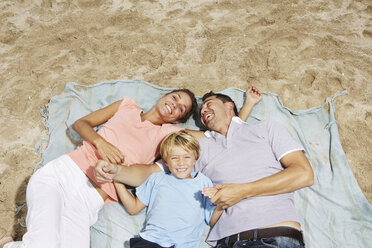 Spanien, Familie liegt am Strand von Palma de Mallorca, lächelnd - SKF001225