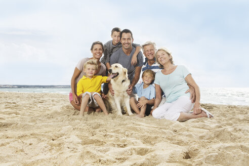 Spain, Portrait of family sitting on beach at Palma de Mallorca, smiling - SKF001193