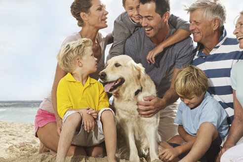 Spanien, Familie sitzt am Strand von Palma de Mallorca, lächelnd - SKF001194