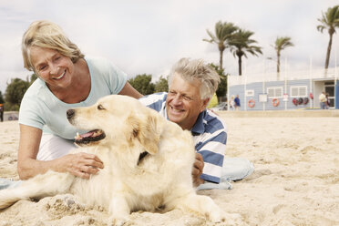 Spanien, Seniorenpaar mit Hund am Strand von Palma de Mallorca, lächelnd - SKF001236