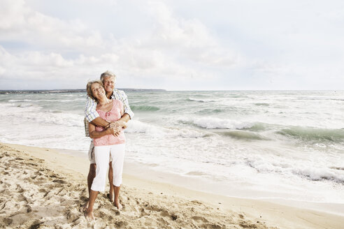 Spanien, Älteres Paar umarmt sich am Strand von Palma de Mallorca - SKF001183