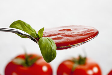 Spoon with tomato sauce and basil leaf, close up - CSF018459