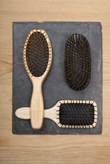 Various hair brushes on slate board, close up - TDF000045