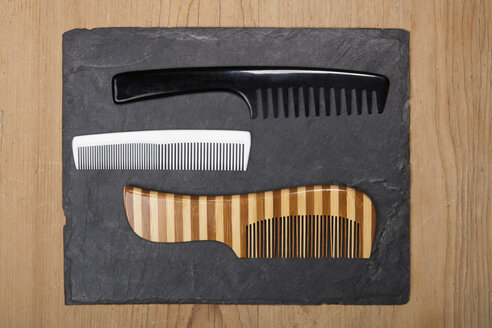 Various hair combs on slate board, close up - TDF000044