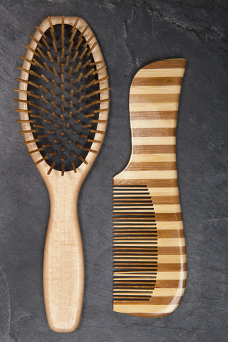 Haarbürste und Kamm auf Schiefertafel, Nahaufnahme, lizenzfreies Stockfoto
