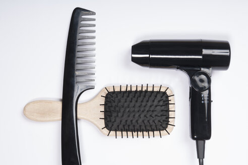 Hair dryer, comb and brush on white background, close up - TDF000048