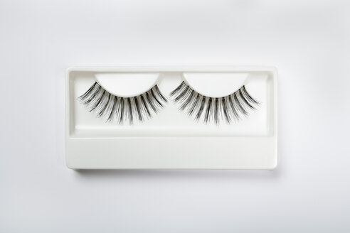 Fake eyelashes in plastic container on white background - TDF000028