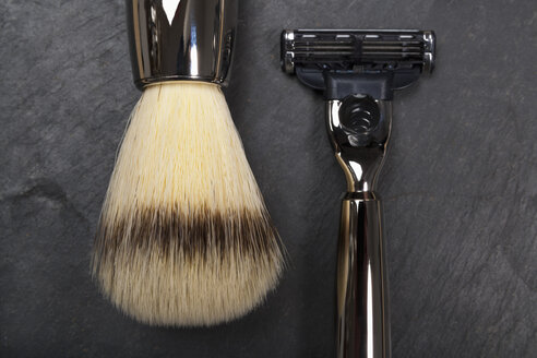 Shaving brush, razor and razor blade on slate board, close up - TDF000023