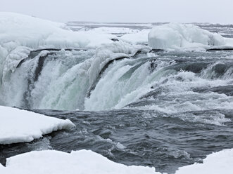 Island, Blick auf den Godafoss-Wasserfall in winterlicher Landschaft - BSCF000263