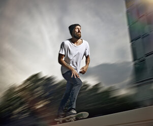 Germany, Cologne, Young man skating on skateboard - RHYF000354