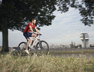 Deutschland, Köln, Mittlerer Erwachsener Mann fährt Fahrrad - RHYF000359