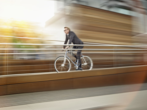 Germany, Cologne, Mature man riding bicycle stock photo