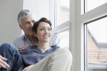 Germany, Bavaria, Munich, Couple sitting at window, smiling - RBF001282