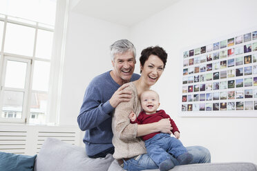 Deutschland, Bayern, München, Familienporträt auf Couch sitzend, lächelnd - RBF001288