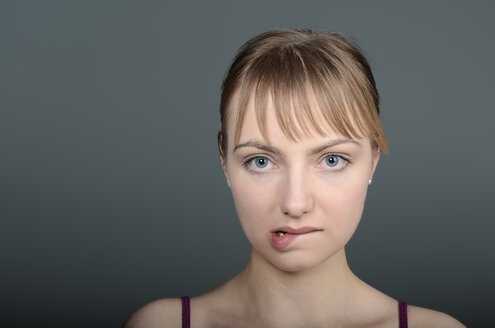 Porträt einer jungen Frau, die auf die Lippen beißt, Nahaufnahme - ONF000117