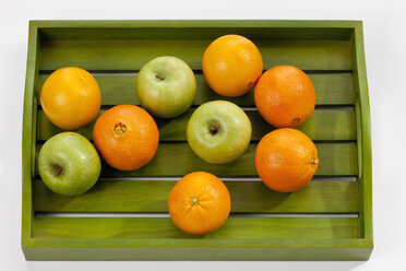 Grüne Äpfel und Orangen auf Holztablett, Nahaufnahme - CSF018493