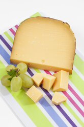 Gouda-Käse mit Trauben auf Schneidebrett, Nahaufnahme - CSF018687