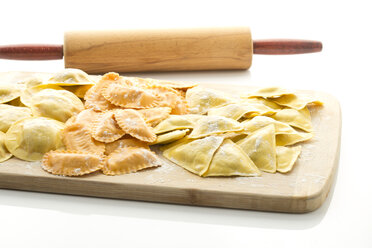 Verschiedene mit Tomaten, Schinken und Pilzen gefüllte Ravioli auf einem Schneidebrett - MAEF006377