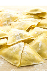 Ravioli filled with mushrooms on chopping board, close up - MAEF006379