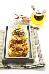 Verschiedene Ravioli gefüllt mit Tomaten, Schinken und Pilzen auf einem Teller - MAEF006418
