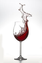 Rotwein spritzt im Glas auf weißem Hintergrund - PSAF000008