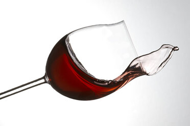 Rotwein spritzt im Glas vor weißem Hintergrund - PSAF000007
