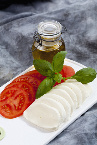 Mozzarellascheiben, Tomaten und Basilikum auf dem Schneidebrett, Nahaufnahme, lizenzfreies Stockfoto