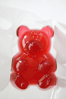 Big red jellybaby in cellophane, studio shot - HSTF000028