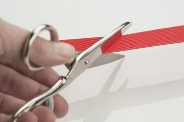 Human hand cutting inauguration red ribbon, close-up - CRF002371