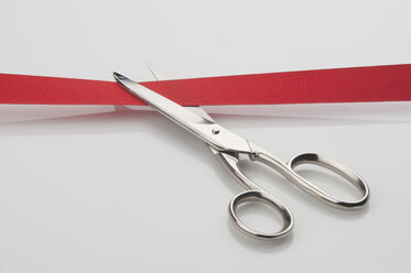 Scissors cutting inauguration red ribbon, close-up - CRF002368