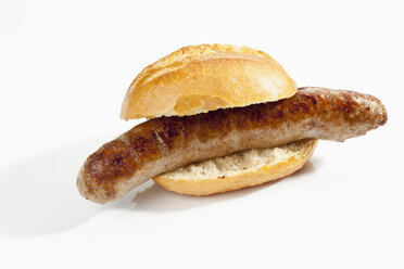 Bread roll with grilling sausage on white background, close up - CSF018754