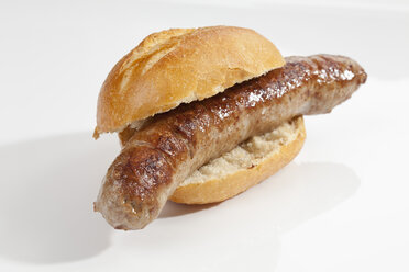 Bread roll with grilling sausage on white background, close up - CSF018755