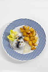 Rollmopshering mit Röstkartoffeln und Zwiebeln auf einem Teller - CSF018784