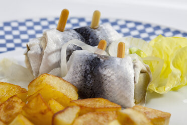 Rollmopshering mit Röstkartoffeln und Zwiebeln auf einem Teller - CSF018787