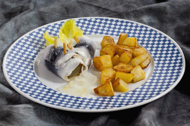 Rollmopshering mit Röstkartoffeln und Zwiebeln auf einem Teller - CSF018789