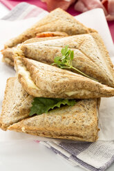 Schinken-Käse-Sandwich mit Tomaten auf Serviette - MAEF006443