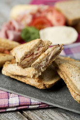 Schinken-Käse-Sandwich mit Tomaten auf Schneidebrett - MAEF006437