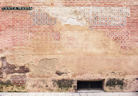 Spanien, Malaga, Backsteinmauer und Straße Santa Maria, Nahaufnahme, lizenzfreies Stockfoto