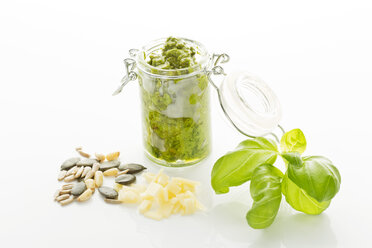 Basil Pesto in jar with seeds on white background, close up - MAEF006470