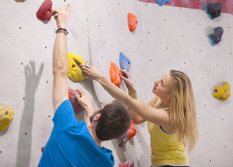 Germany, Bavaria, Munich, Young man helping woman to climb - HSIYF000189