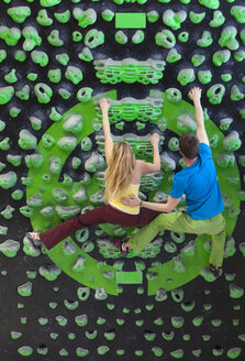 Germany, Bavaria, Munich, Young man helping woman to climb - HSIYF000193