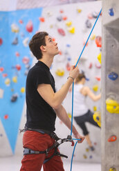 Deutschland, Bayern, München, Mann bereitet sich zum Bouldern vor, Frau im Hintergrund - HSIYF000169