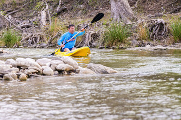 USA, Texas, Älterer Mann fährt Kajak auf dem Frio River - ABAF000809