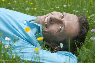 Deutschland, Bayern, München, Porträt eines reifen Mannes, der sich im Garten entspannt, lächelnd - CRF002373